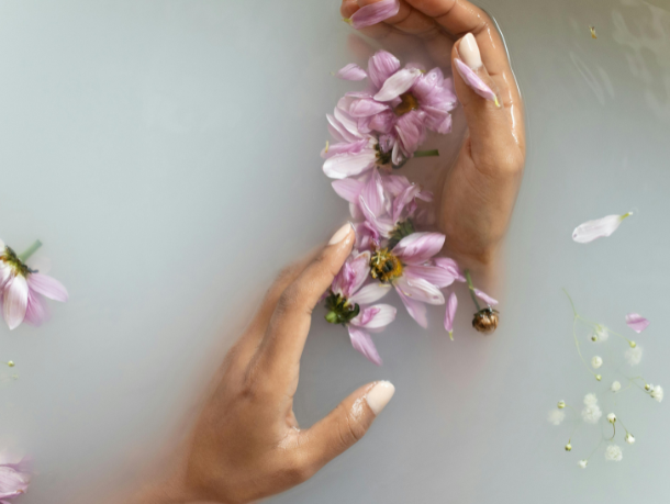 image of hands in water with purple flowers