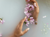 image of hands in water with purple flowers